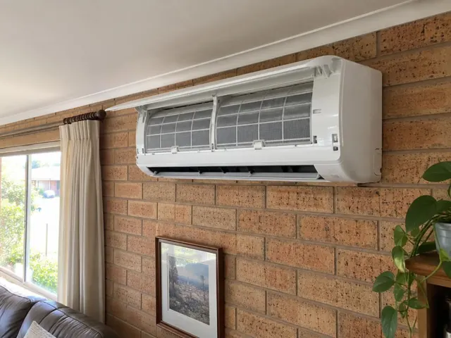 Clean split system mounted high on a brick living room wall with filters visible in Para Hills